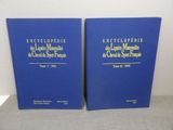 two blue books with gold lettering on them sitting on a table