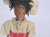 a doll that is wearing a pink dress and a hat