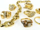 plusieurs types de bagues et de bracelets en or, posés sur un fond blanc