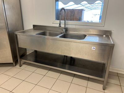 a stainless steel sink and a stainless steel refrigerator in a kitchen