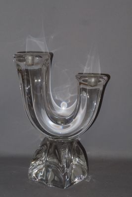 a glass candle holder with smoke coming out of it