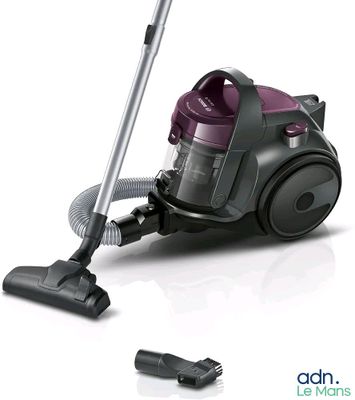un aspirateur posé par terre à côté d'un cordon d'alimentation