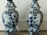 pair of blue and white vases with birds on top of them