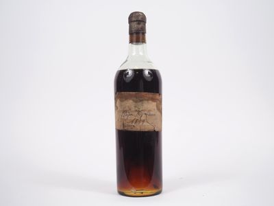 une vieille bouteille d'alcool posée sur une surface blanche