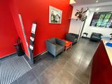 a red wall in a room with two chairs and a table