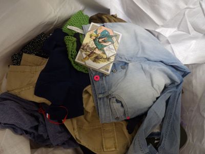 a pile of clothes and a pair of scissors on a bed