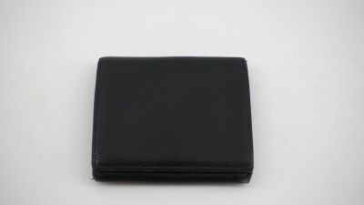 un portefeuille en cuir noir posé sur une surface blanche