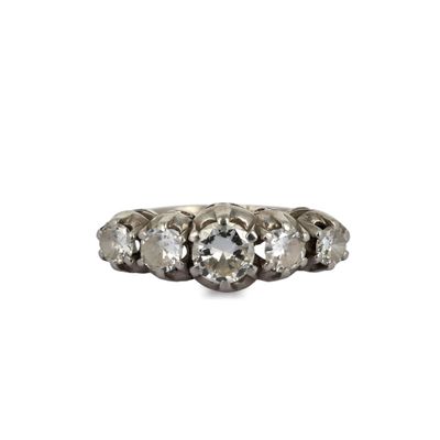 un gros plan d'une bague à trois pierres sur fond blanc