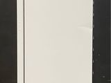 an image of a white refrigerator on a concrete floor