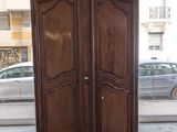 a large wooden armoire in a room with a car in the background