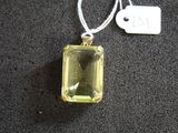 pendentif en cristal jaune avec une étiquette sur un fond noir