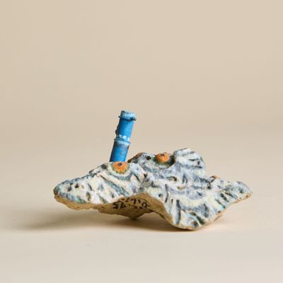 une petite figurine représentant un phare perché au sommet d'un rocher