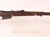 un vieux fusil en bois posé sur un socle en acrylique transparent