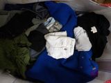 un sac rempli de vêtements posé sur un lit