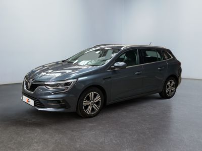 Une voiture grise est garée dans une pièce aux murs blancs