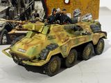 a toy army vehicle that is sitting next to a book