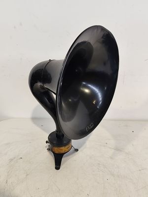 un vieux gramophone noir posé sur un meuble blanc