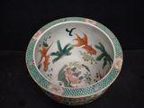 a bowl with birds and flowers on it on a black surface