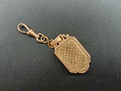 un porte-clés plaqué or orné d'un motif raffiné