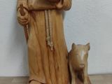une statue représentant un homme tenant un livre et un chien