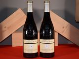 two bottles of wine sitting on a table next to each other