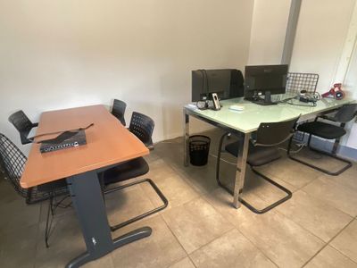 des tables et des chaises dans une pièce équipée d'un bureau et d'un ordinateur