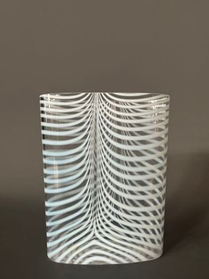 un gros plan d'un vase en verre orné d'un motif ondulé