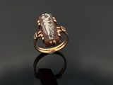 une bague en or ornée d'une incrustation représentant une femme tenant un enfant dans ses bras