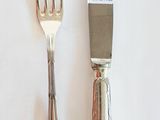 deux fourchettes et un couteau sur une table blanche
