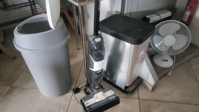 a vacuum that is on the floor next to a trash can