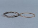 deux bracelets en argent et une bague en or sur fond bleu
