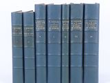 six livres bleus sont alignés sur une surface blanche