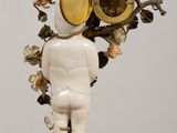 a figurine of a man with a clock on his head