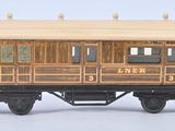 un petit wagon en bois posé sur une surface blanche