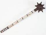 a wooden stick with a flower on it on a white surface
