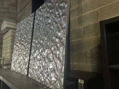une photo d'un grand écran métallique à l'intérieur d'un bâtiment