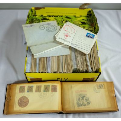 an open book sitting on top of a table next to a pile of stamps