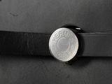 a belt with a coin on it that is attached to a hat