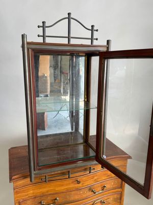 une petite armoire en bois surmontée d'un miroir