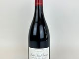 une bouteille de vin rouge posée sur une table blanche