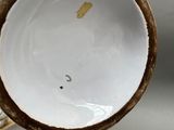 a close up of a vase with a bird on it