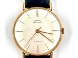 a close up of a watch on a white surface