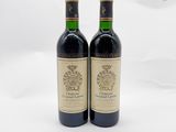 deux bouteilles de vin rouge posées l'une à côté de l'autre sur une surface blanche