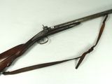 an old rifle with a wooden handle and a wooden sling