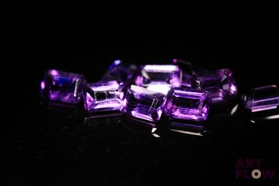 perles d'améthorate violettes sur une surface noire avec un fond noir