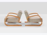 a pair of lounge chairs in the style of person