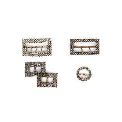 trois boucles métalliques et une épingle sur un fond blanc