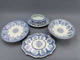 un service composé de quatre assiettes et tasses bleues et blanches