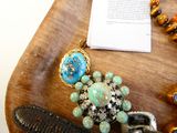 un plateau en bois sur lequel sont posés des bijoux et un livre