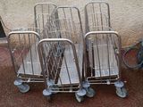 three silver shopping carts sitting next to each other in front of a wall
